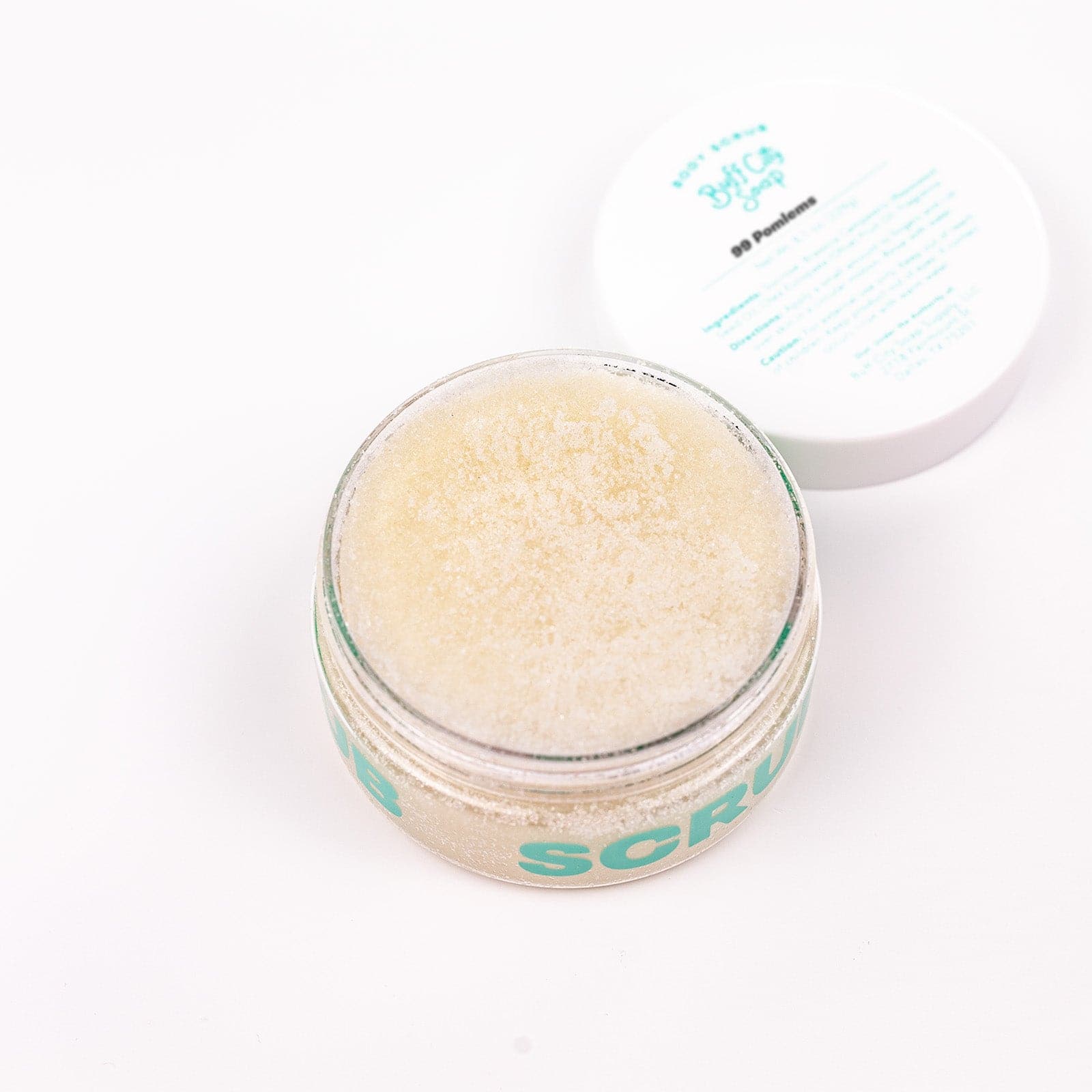 Clear Body Scrub container with lid open against white background shot from above