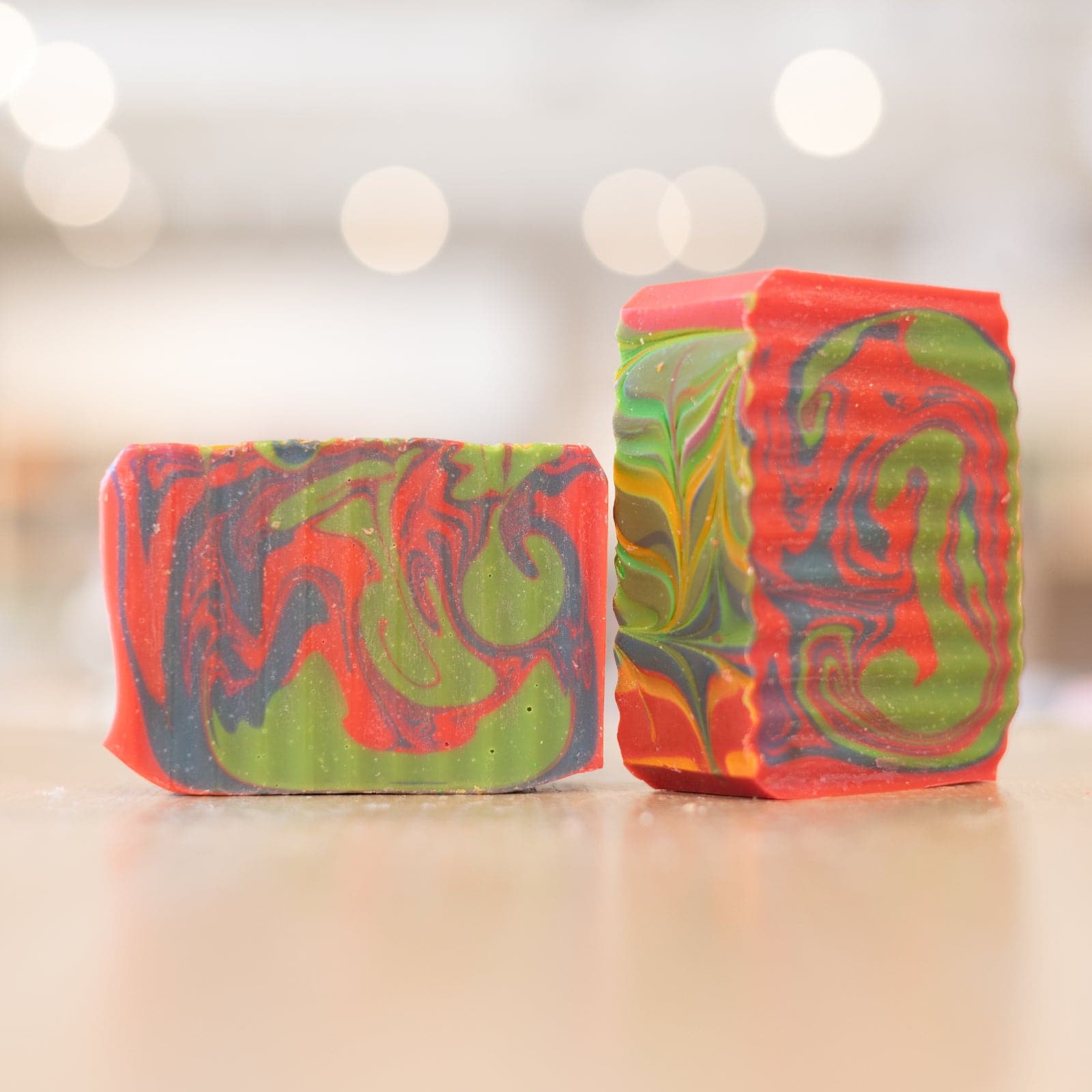 Two Fruity Loopy Soap Bars with multicolor design on wooden counter