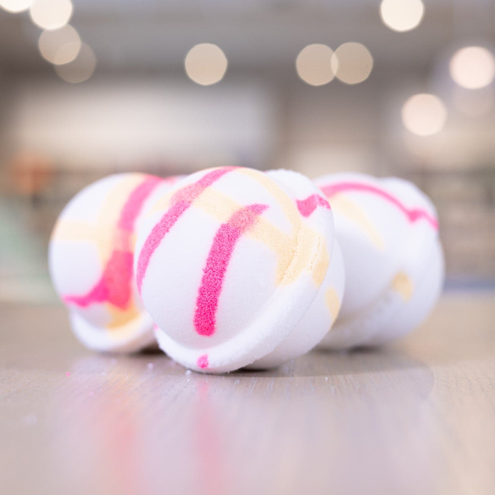 Island Nectar Bath Bombs with pink and yellow design lined up on counter