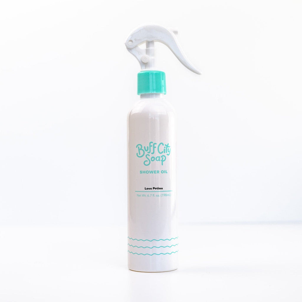 Love Potion Shower Oil spray bottle with teal finishes against white background