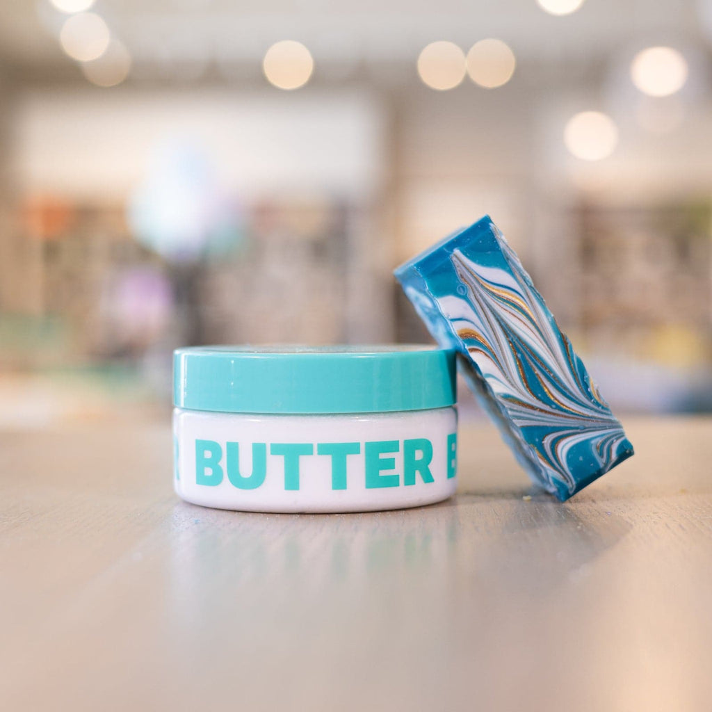 Buff City Soap's magnolia scented body butter with a bar of soap rested on it