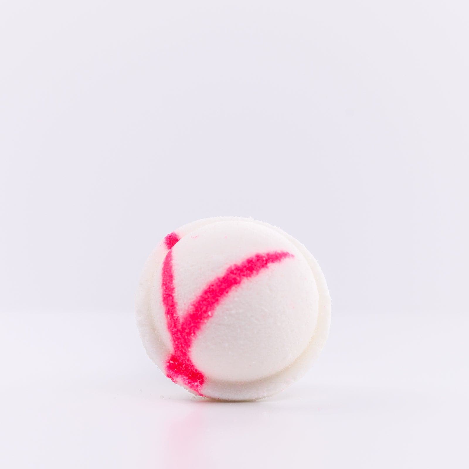 the top of white Mermaid Bath Bomb with a pink "X" design on it