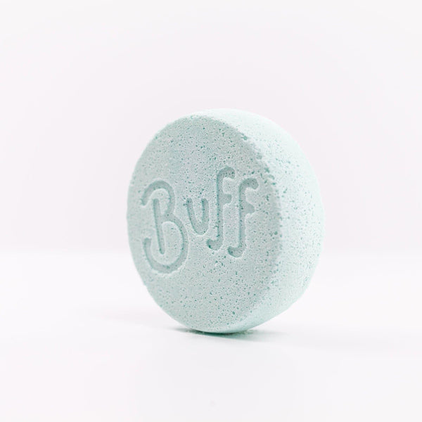 angled left view of light blue Narcissist Shower Fizzy with "Buff" engraved in it