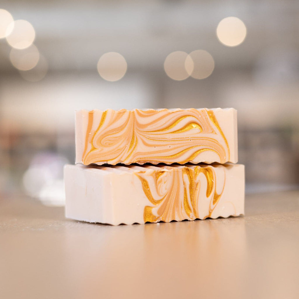 Two Oatmeal Honey Shea Butter Soap Bars stacked on top of each other with orange swirls