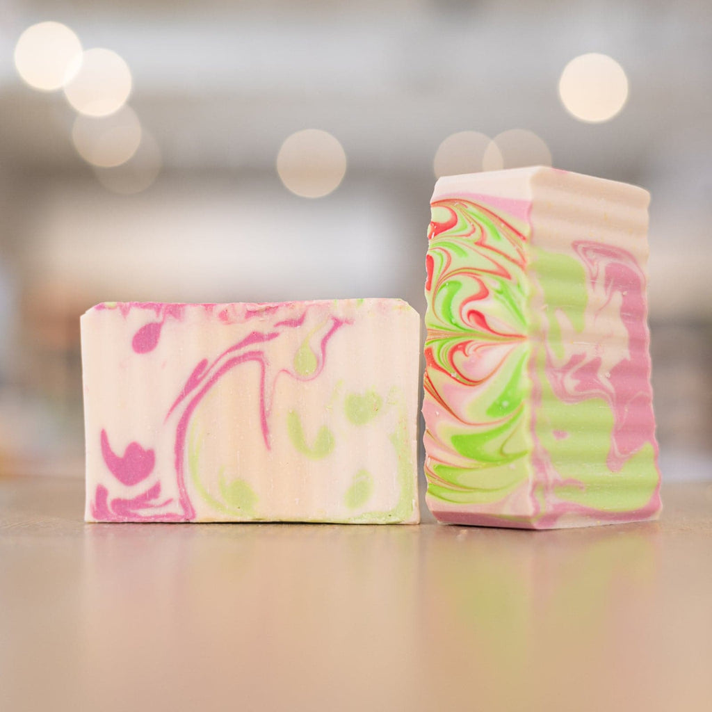Two White Jasmine Soap Bars with pink and green designs on counter